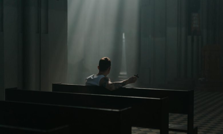 a back view of a man sitting on a pew